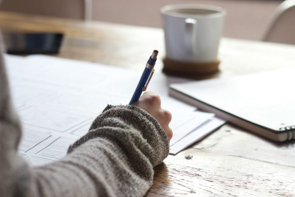 woman drawing out wireframes for website design.